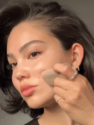 Blending the skin tint balm across the cheek